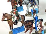 many figurines of soldiers on display on a white surface