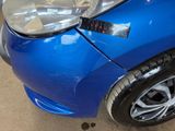 a close up of a blue car with a sticker on the front of it