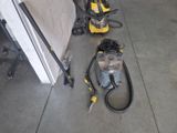 two vacuums on the floor next to a wall