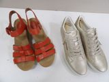 two pairs of silver and red shoes sitting next to each other
