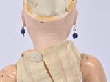 a wooden doll with a metal belt on it ' s back