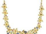 un collier en or orné de pierres multicolores sur fond blanc