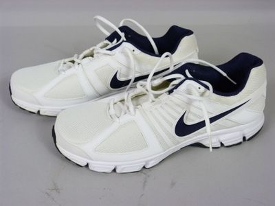 des chaussures de course blanches et bleues à lacets sur un fond gris