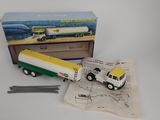 a toy truck that is sitting next to a box of pencils