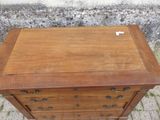 une petite commode en bois posée sur le trottoir