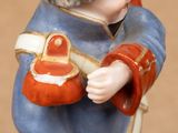 a figurine of a boy with a baseball bat and glove