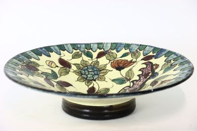 a bowl with a floral design on it on a stand
