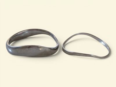 pair of silver rings sitting on top of each other on a white surface