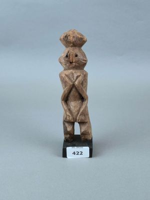une petite statue en bois représentant un homme coiffé d'un chapeau