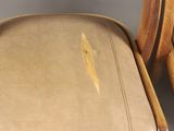 a pair of wooden chairs with leather upholstered seats