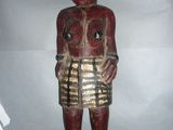 statue en bois représentant un homme portant une jupe et un bandeau