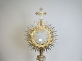 a gold and silver statue of a person holding a cross