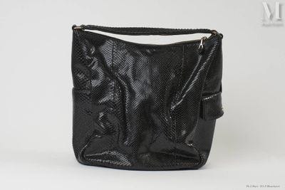 un sac à main noir posé sur une table blanche