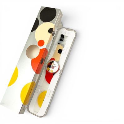 une boîte avec une montre à l'intérieur sur une surface blanche
