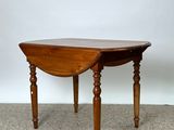 a small table with a wooden top on a carpeted floor