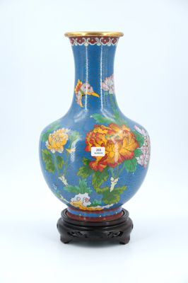 a blue vase with flowers on it sitting on a stand