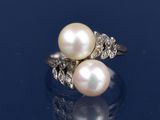 une image représentant une bague en perle blanche et diamants sur un fond bleu