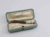 une petite boîte contenant un stylo, posée sur une table