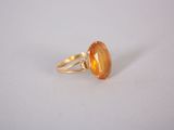a yellow ring with an oval stone on top of it