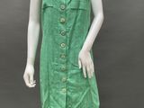a mannequin wearing a green dress with buttons on it