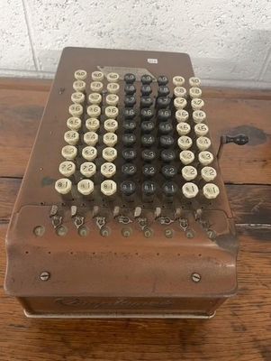 an old fashioned typewriter sitting on top of a wooden table