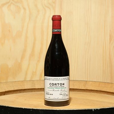 a bottle of wine sitting on top of a barrel