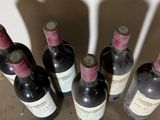 several bottles of wine are lined up in a row on a table