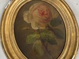 un tableau représentant une rose, dans un cadre doré, accroché au mur