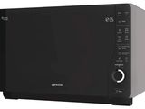 un four à micro-ondes noir posé sur un comptoir blanc
