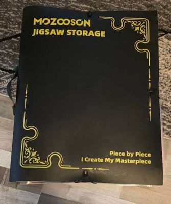 a black book sitting on top of a wooden floor next to a table