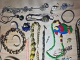 many different types of necklaces and bracelets laid out on a table