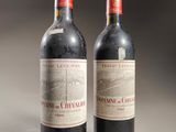two bottles of red wine sitting next to each other on a table