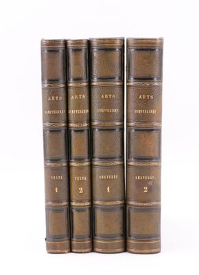 quatre livres anciens sont alignés sur une surface blanche