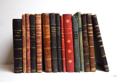 plusieurs vieux livres sont empilés sur une étagère
