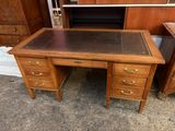 un bureau en bois avec un plateau en cuir et deux tiroirs