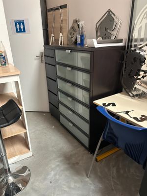 une image représentant une pièce avec un bureau, une chaise et une planche à repasser
