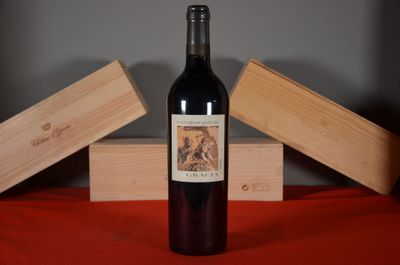 a bottle of wine sitting on a table next to two wooden boxes