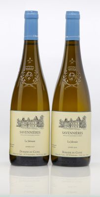 two bottles of wine sitting next to each other on top of a table