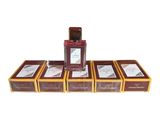 four boxes of perfume sitting on top of each other on a white surface