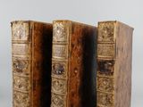 two old books sitting on top of each other on a table