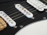 a close up of a white electric guitar on a table