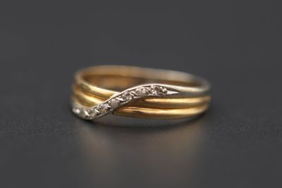 gros plan d'une bague en or et diamants sur une surface noire