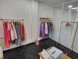 a photo of a clothing store with clothes on hangers