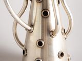 a silver vase that is sitting on a table
