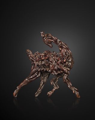 a bronze sculpture of a deer on a black background