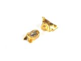 une paire de boucles d'oreilles en or sur une surface blanche