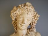 une statue représentant une femme avec une fleur dans les cheveux
