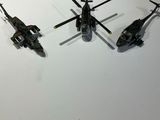 three black helicopters sitting on a white surface next to each other