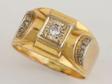 a close up of a gold ring with a diamond in the center