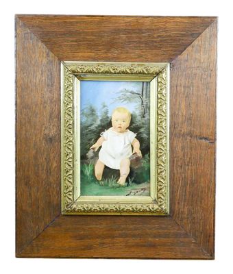 an old picture of a baby in a white dress in a wooden frame